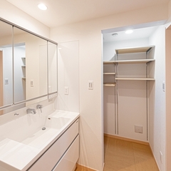 白で清潔感あふれ大容量収納スペースへと繋がるシンプルモダンな洗面所