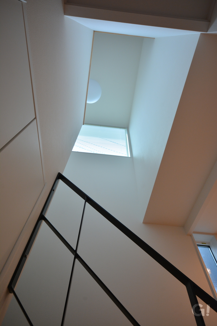 吹き抜け空間から自然光が燦々と降り注ぐナチュラルな家の階段ホール