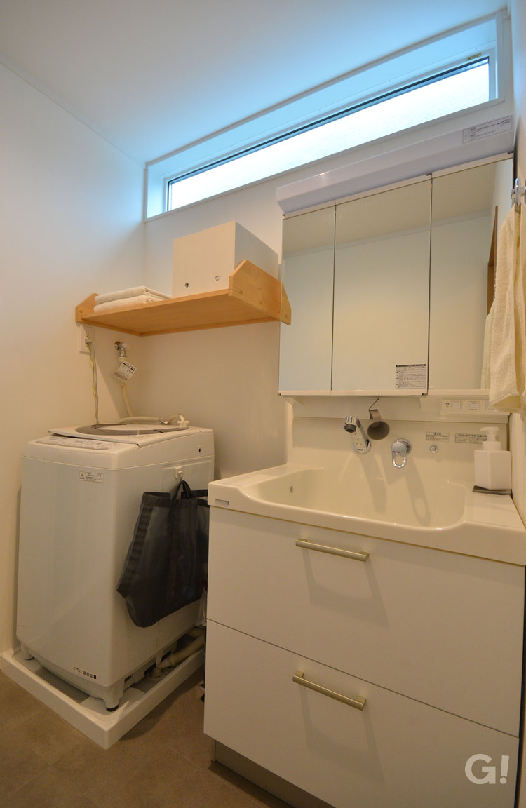 ホワイトで統一された清潔感ある洗面脱衣所の写真