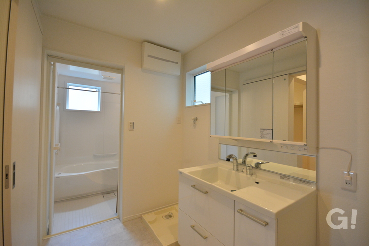 『白で統一され美しく清々しい空間広がるナチュラルな家の洗面所』の写真