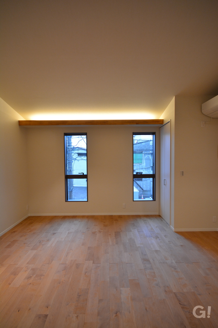2段になった天井空間で灯りがやわらかく光り輝くナチュラルな家の洋室