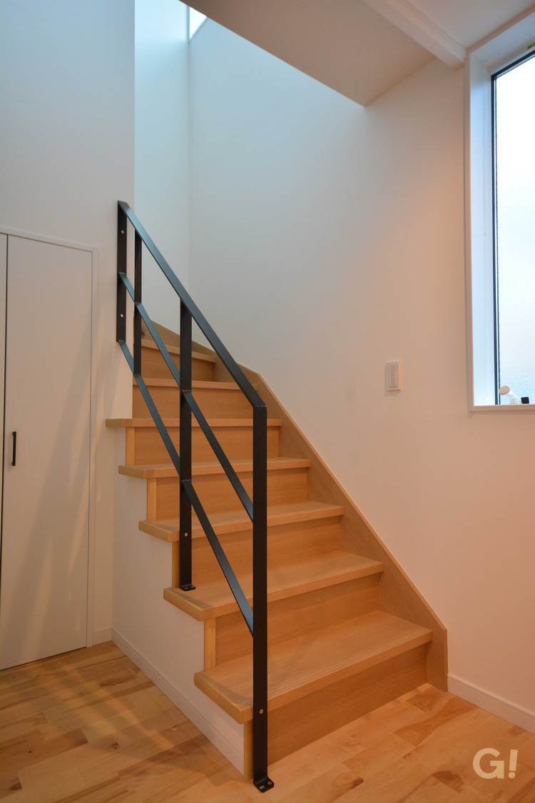 『黒アイアン手すりがカッコよさをプラス！階段下は収納があって便利なナチュラルな家の階段ホール』の写真