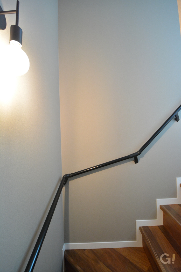 黒アイアン手すりが安全に上り下りを誘導！アースカラーの優しい雰囲気のナチュラルな家の階段