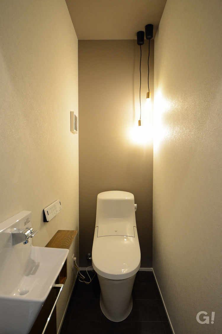 黒でかっこいい照明がパッと明るく光り輝くナチュラルな家のトイレ