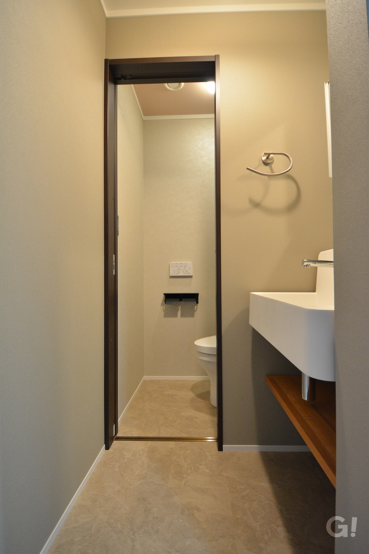 『アースカラーで優しく癒しタップリの空間！フラットに繋がる洗面室＆トイレ』の写真