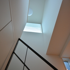 吹き抜け空間から自然光が燦々と降り注ぐナチュラルな家の階段ホール