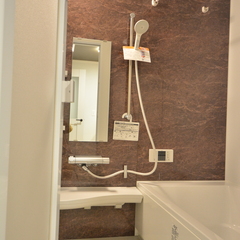 大理石風のブラウンの壁が高級感漂い美しいナチュラルな家の浴室