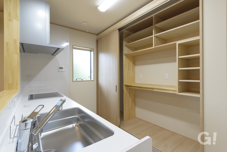 シンプルで機能性の高い収納棚付きキッチンのある注文住宅の写真