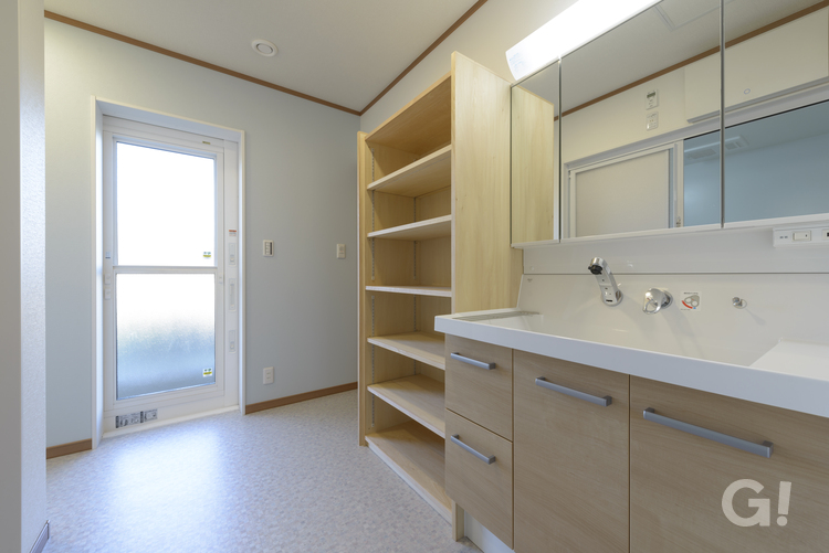 ナチュラルなデザインの収納スペースと洗面所の写真