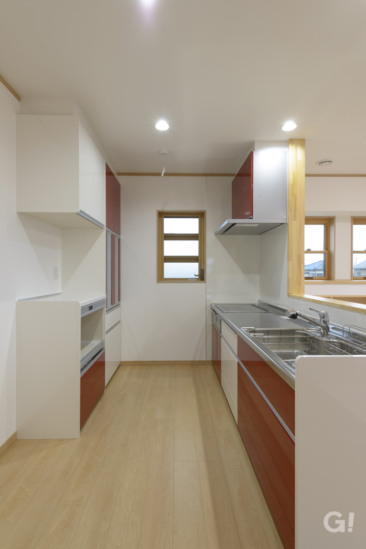和モダン住宅の赤が引き立つシステムキッチン空間の写真