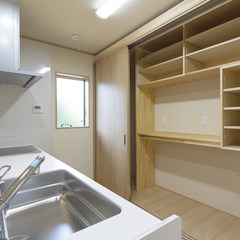 シンプルで機能性の高い収納棚付きキッチンのある注文住宅