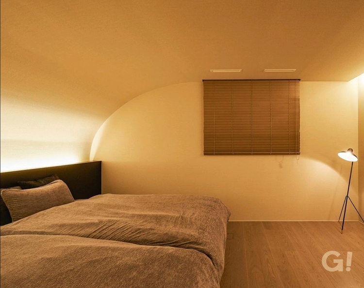 アール壁を施した間接照明のある寝室の写真
