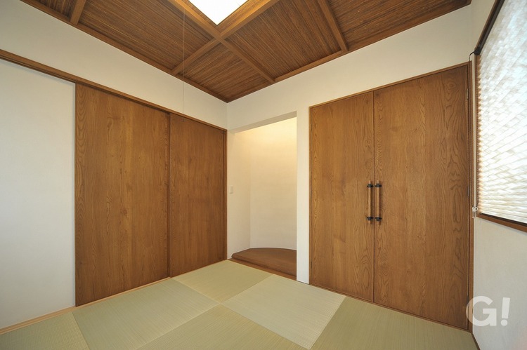 リビングと大きな扉でつながるモダンテイストな和室の写真