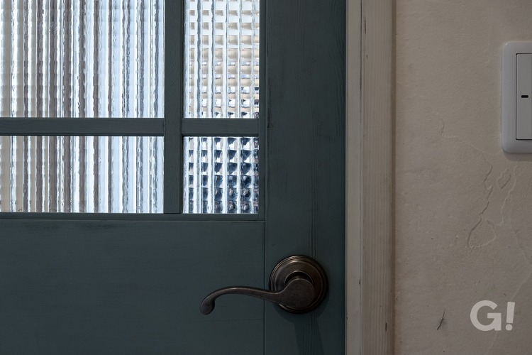 アンティーク塗装がかわいい扉とアイアン格子の入ったアンティークガラスの小窓の写真