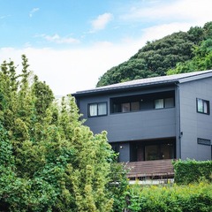 緑と調和するグレーの外壁のモダンなお家