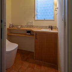 木のカウンターと緑のアクセントモザイクタイルがかわいい手洗い