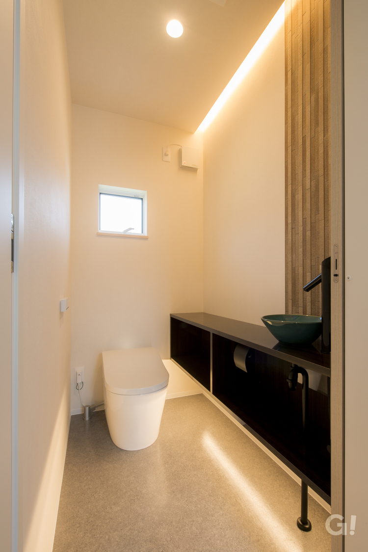 間接照明で落ち着いたトイレ空間。調湿性のあるタイルがアクセント