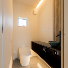 間接照明で落ち着いたトイレ空間。調湿性のあるタイルがアクセント