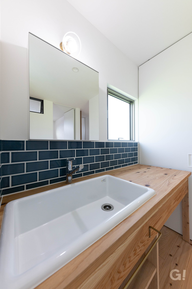 『ダークネイビーのタイルが上品でお洒落！家族で共有する空間がいいシンプルモダンな洗面室』の写真