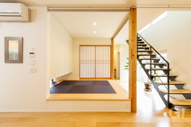 シンプルにデザインされた小上がりの和室や鉄骨階段ともつながり、広がりを感じながらも長方形で使いやすいリビングの写真