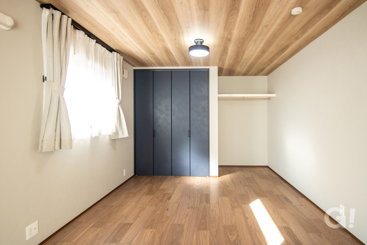 木のぬくもりとネイビーの落ち着きが調和する心地よい寝室の写真