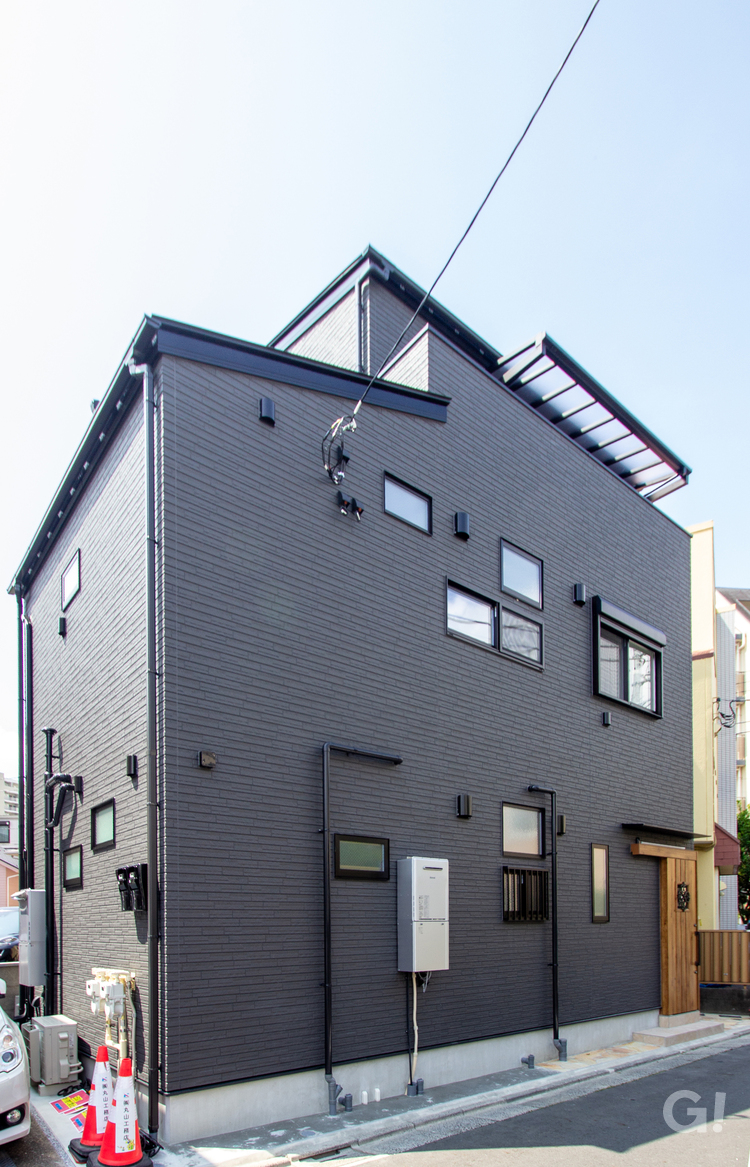 黒の外観と木の温もりが調和する、2つの玄関がつなぐ心地よい距離の二世帯住宅の写真