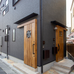 黒の外観と木の温もりが調和する、2つの玄関がつなぐ心地よい距離の二世帯住宅