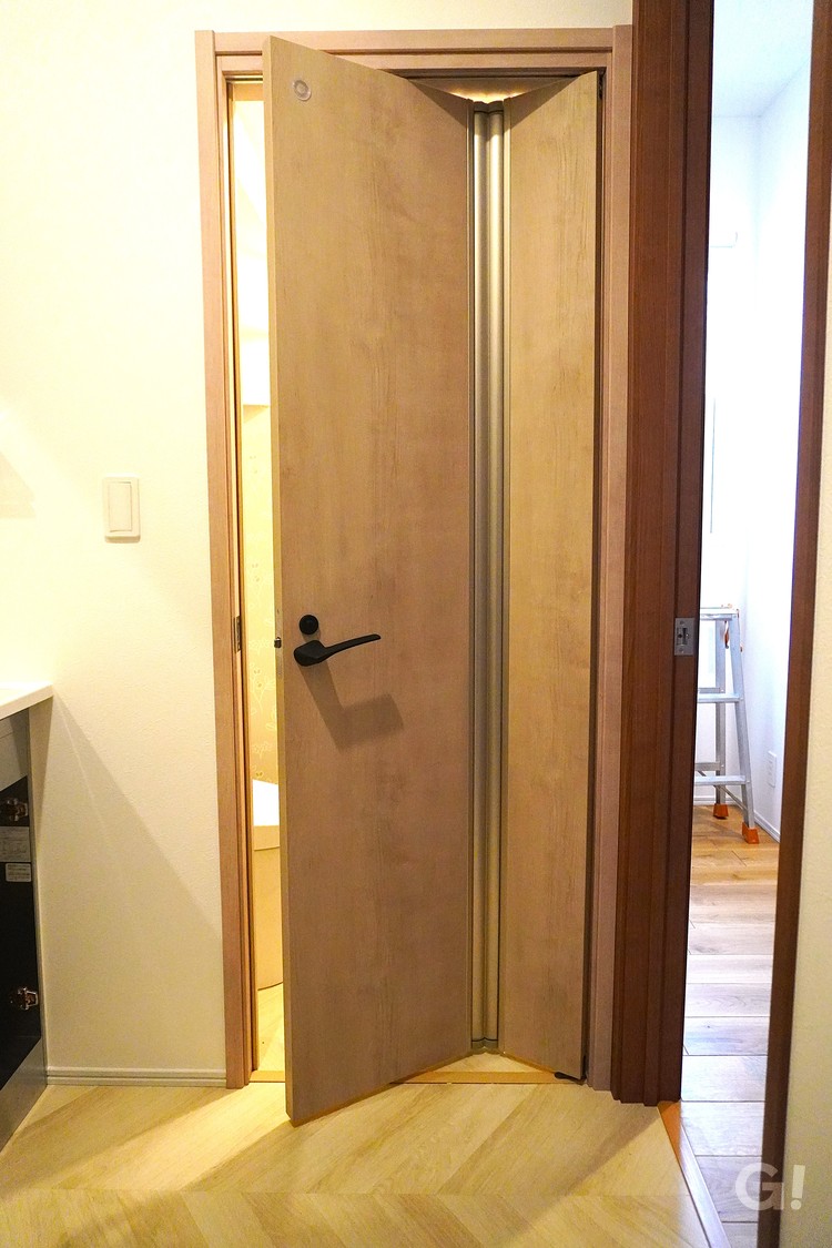 狭い廊下でも出入りスムーズ。省スペースを叶える折れ戸タイプのトイレドア。の写真