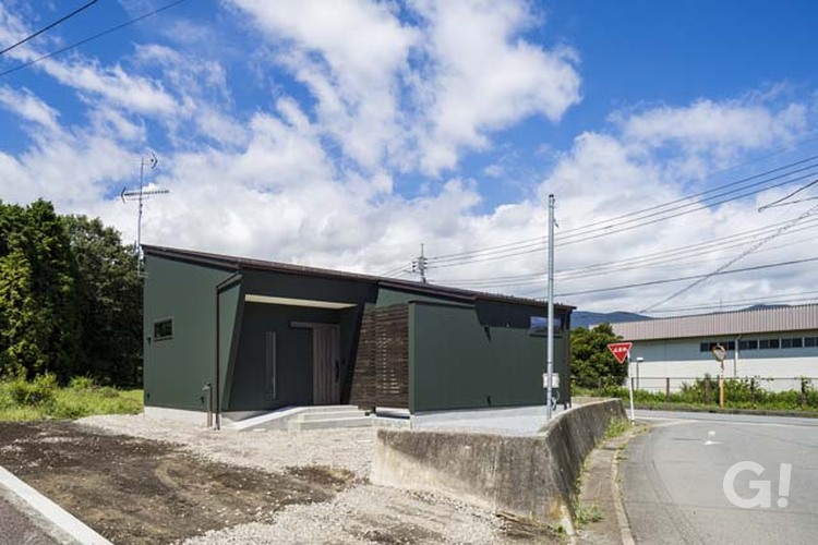 深緑の壁が印象的な平屋の画像