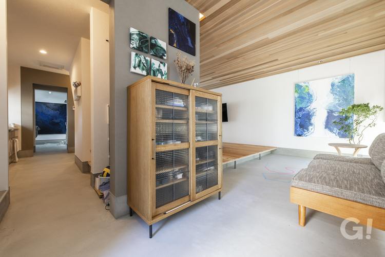 玄関からの目線。幅広の土間がリビングを囲む。飾られた絵画は、オーナー様の作品。奥に見えるのはアトリエ。