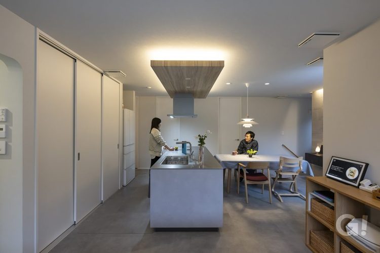 フロアの中心にあるのは、ホテルライクなオープンキッチン 。背面に3枚引き戸の大型収納とパントリーを配置したことで、生活感の出やすいものをすべて隠すことができる。。間接照明を効果的に使った演出により、夜にはさらにラグジュアリーな雰囲気が高まります 。