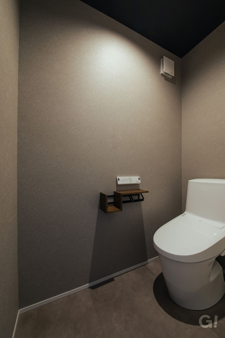 落ち着いた色合いのトイレは、ペーパーホルダーがアクセントに