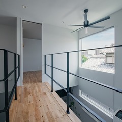 吹抜けに挟まれた空中廊下、目線に合わせた大きな高窓が気持ちいい