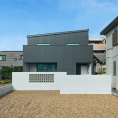 人通りに配慮してブロックウォールで緩やかに目隠しを施した、シンプルモダンなデザインが特徴の外観