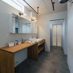 造作の洗面台はメイクもできるよう長いカウンターとワイドな鏡を採用した
