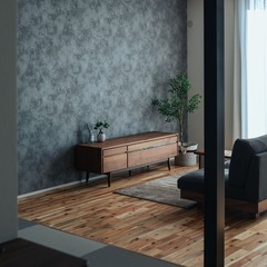 テレビボードの壁に貼ったグレーのクロスがアクセントに