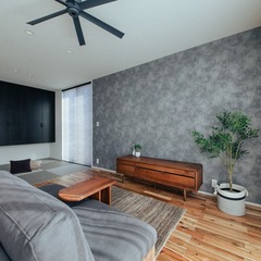 テレビボードの壁に貼ったグレーのクロスが空間を引き締める