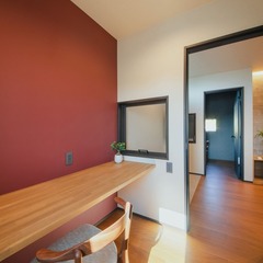 ご主人の書斎と向い合せで配置した奥様の書斎は、赤いアクセントクロスが映える