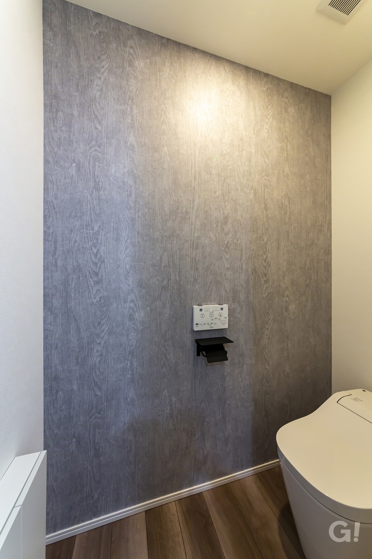 アクセントクロスが映える、落ち着きのあるトイレ空間の写真