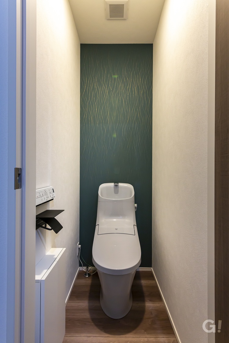 アクセントクロスが映える、落ち着きのあるトイレ空間の写真