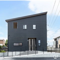 ブラックを基調とした外観に、木目調の軒天がやさしい温もりを添えるモダンな住まい