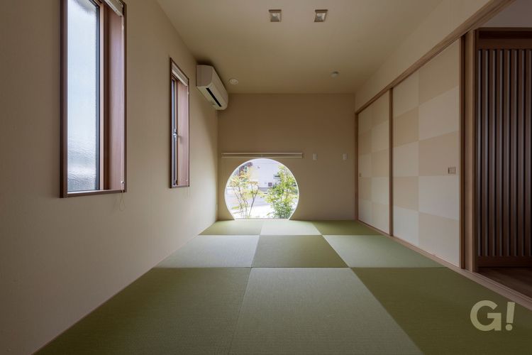 丸窓越しに、坪庭を望む和室