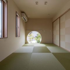丸窓越しに、坪庭を望む和室